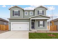 Two-story house with a white double garage door and gray siding at 2215 Alyssa St, Fort Lupton, CO 80621