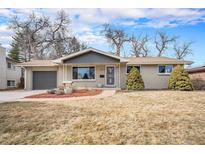 Charming single-story home featuring mature trees, landscaped front yard, and a cozy, covered entryway at 8543 W Arizona Dr, Lakewood, CO 80232