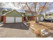 Charming townhome featuring an attached garage, brick accents, and landscaped front yard at 1922 Lydia Dr # 82, Lafayette, CO 80026