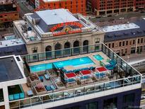 Stunning rooftop pool with lounge seating and views of the city's iconic Union Station at 1750 Wewatta St # 704, Denver, CO 80202