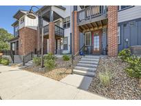 Front view of townhome with brick accents and small front patio at 9490 W 14Th Ave # 3, Lakewood, CO 80215