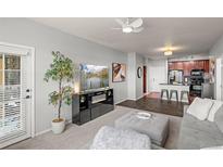 Cozy living room with modern furniture, stylish decor, and a view into the kitchen at 15460 Canyon Gulch Ln # 105, Englewood, CO 80112