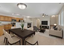 Bright, open living room features a fireplace, modern decor, and seamless flow to the dining area at 5255 Memphis St # 1009, Denver, CO 80239