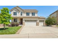 Inviting two-story home featuring a three car garage, manicured lawn, and charming front porch at 4920 S Netherland Way, Centennial, CO 80015