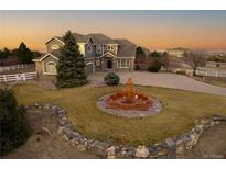 Charming two-story home with stone accents, a water fountain and a landscaped yard, exuding curb appeal at 9407 E 147Th Pl, Brighton, CO 80602