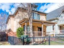 Charming two-story home featuring a covered porch with decorative columns and a well-maintained front yard at 433 N Ogden St, Denver, CO 80218