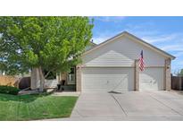 Charming home featuring a two-car garage, well-manicured lawn, and an American flag at 12513 Alcott St, Broomfield, CO 80020