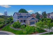 Charming two-story home featuring a stone facade, three-car garage, covered porch, and beautifully landscaped front yard at 14620 Prairie Sky Ln, Broomfield, CO 80023