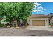 Charming single Gathering home featuring a cozy front patio and a two car garage, with mature landscaping at 6895 Big Horn Trl, Littleton, CO 80125