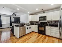Bright kitchen boasts modern appliances, granite counters and hardwood floors at 8751 Pearl St # J3, Thornton, CO 80229