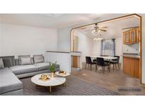 Open-concept living area featuring a modern sectional sofa and dining table with stylish chairs at 1683 Monroe St, Strasburg, CO 80136