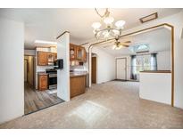Bright living room features an open floor plan, skylight, and easy access to the kitchen at 1683 Monroe St, Strasburg, CO 80136