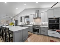 Bright, spacious kitchen with gray cabinetry, stainless steel appliances, and quartz countertops and hardwood flooring at 2687 E 124Th Pl, Thornton, CO 80241