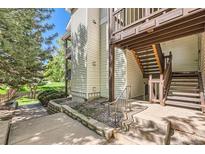 A view of a home's wood-sided exterior with stairs leading up to a balcony at 17381 E Mansfield Ave # 711L, Aurora, CO 80013