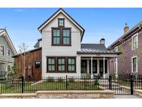 Charming two-story home featuring white siding, black-trimmed windows, and a quaint front porch at 208 N Ridge St, Breckenridge, CO 80424