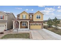 Inviting two-story home with a stone-accented facade, covered porch, and a two-car garage with a concrete driveway at 19760 W 59Th Dr, Golden, CO 80403