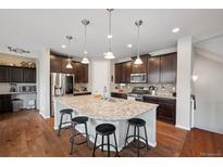Gourmet kitchen boasts an island, stainless steel appliances, and dark wood cabinetry at 19760 W 59Th Dr, Golden, CO 80403