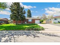 Charming brick ranch-style home with a well-maintained lawn and mature trees under a blue sky at 12046 W Green Mountain Dr, Lakewood, CO 80228