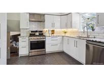 Modern kitchen featuring white cabinets, stainless steel appliances, granite countertops, and subway tile backsplash at 10909 W 65Th Way, Arvada, CO 80004