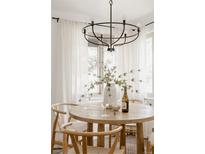 Bright dining area features a round wood table, modern lighting, and sheer curtains at 916 Florence St, Aurora, CO 80010