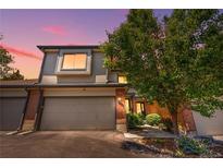 Inviting townhouse with a two-car garage, brick accents, and mature landscaping at 6375 S Jackson St, Centennial, CO 80121