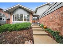 Inviting front entrance features a brick exterior, beautiful front door, and landscaped yard at 14562 W 3Rd Ave, Golden, CO 80401