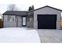 Updated Ranch home with a modern black garage door and snow-covered front yard at 16930 E Wagontrail Pkwy, Aurora, CO 80015