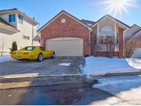 Brick ranch home with attached garage and snowy front yard at 3200 Masters Point Pt, Castle Rock, CO 80104