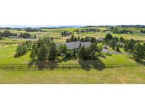 Aerial view of house on large lot with mountain views and wooden fence at 306 Andrea Cir, Parker, CO 80138