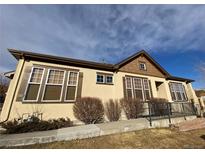 Inviting single-story home featuring beautiful earth-tone stucco, wood shutters, and well-maintained landscaping at 11925 W Ida Dr, Littleton, CO 80127