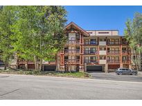 Attractive condo building with wood beam accents and private balconies, nestled among mature trees at 815 Columbine Rd # 22, Breckenridge, CO 80424