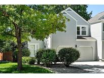 Charming two-story home with a well-maintained lawn, mature tree, and a two car garage at 6401 S Forest St, Centennial, CO 80121