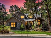 Charming home with stone accents, well-manicured lawn, and mature trees in a peaceful neighborhood at 484 Hyland Dr, Castle Rock, CO 80108