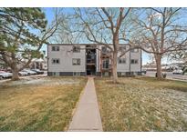Apartment building featuring gray siding, black trim, and a well-maintained lawn at 16259 W 10Th Ave # A4, Golden, CO 80401