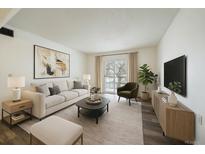 Bright living room featuring neutral tones, modern decor, and a sliding door to a balcony for natural light at 16259 W 10Th Ave # A4, Golden, CO 80401