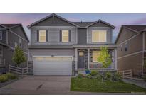Two story home with a covered porch, a lawn, a two car garage, and grey siding at 4781 Rosette St, Castle Rock, CO 80104