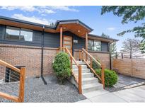 Inviting front entrance with modern wood accents and stylish stair railing at 2067 Depew St, Edgewater, CO 80214