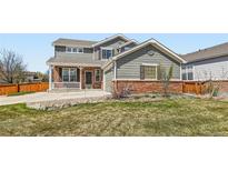 Charming two-story home featuring a front porch, well-maintained lawn, and brick accents at 3097 Madison Ln, Broomfield, CO 80023