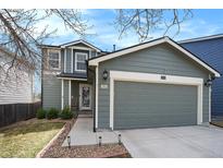 Charming two-story home with a well-maintained lawn and a two-car garage in a suburban neighborhood at 16328 E Phillips Ln, Englewood, CO 80112