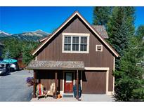 Charming cabin-style home featuring a wood exterior, cozy porch, and stunning mountain views at 302 N Main St, Breckenridge, CO 80424