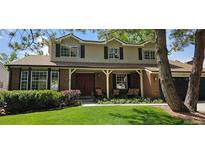 Charming two-story home with brick facade, covered porch, bay window and well-maintained lawn at 7655 S Ogden Way, Centennial, CO 80122