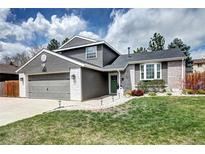 Charming two-story home with a manicured lawn, brick accents, and a well-maintained gray siding at 8581 W Hinsdale Pl, Littleton, CO 80128