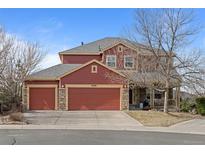 Charming two-story home features a three-car garage, red siding, and a covered front porch at 23101 Timber Spring Ln, Parker, CO 80138