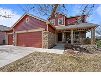 Charming two-story home with a welcoming front porch and a three-car garage in a residential neighborhood at 23101 Timber Spring Ln, Parker, CO 80138