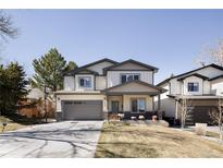 Charming two-story home with a well-manicured lawn, complemented by neutral siding and a paved driveway leading to an attached garage at 3427 S Cherry St, Denver, CO 80222