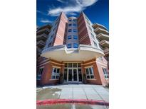 Elegant brick building entrance featuring modern doors and manicured planters for a welcoming arrival at 4875 S Monaco St # 103, Denver, CO 80237