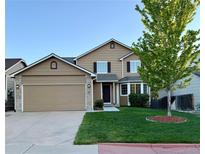 Charming two-story home with a well-maintained lawn and attached two-car garage at 23760 Broadmoor Dr, Parker, CO 80138