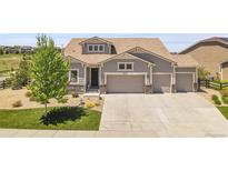 Beautiful two story home featuring a three car garage and manicured front lawn at 8661 S De Gaulle Ct, Aurora, CO 80016