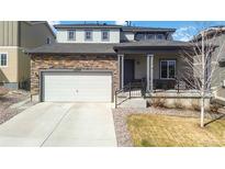 Attractive home with a two-car garage, stone accents, covered entry, and well-maintained lawn at 12759 Buffington Trl, Parker, CO 80134