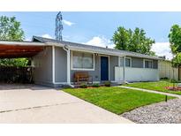 Charming single-story home with a blue front door, well-maintained lawn, and a covered parking area at 5332 Granby St, Denver, CO 80239